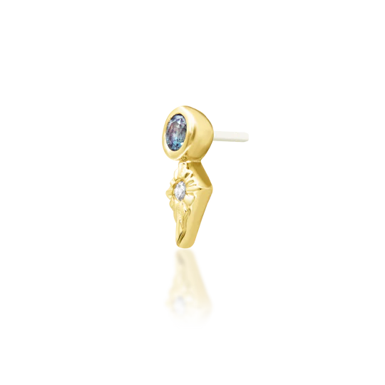 Gold earring with blue gemstone on a white background