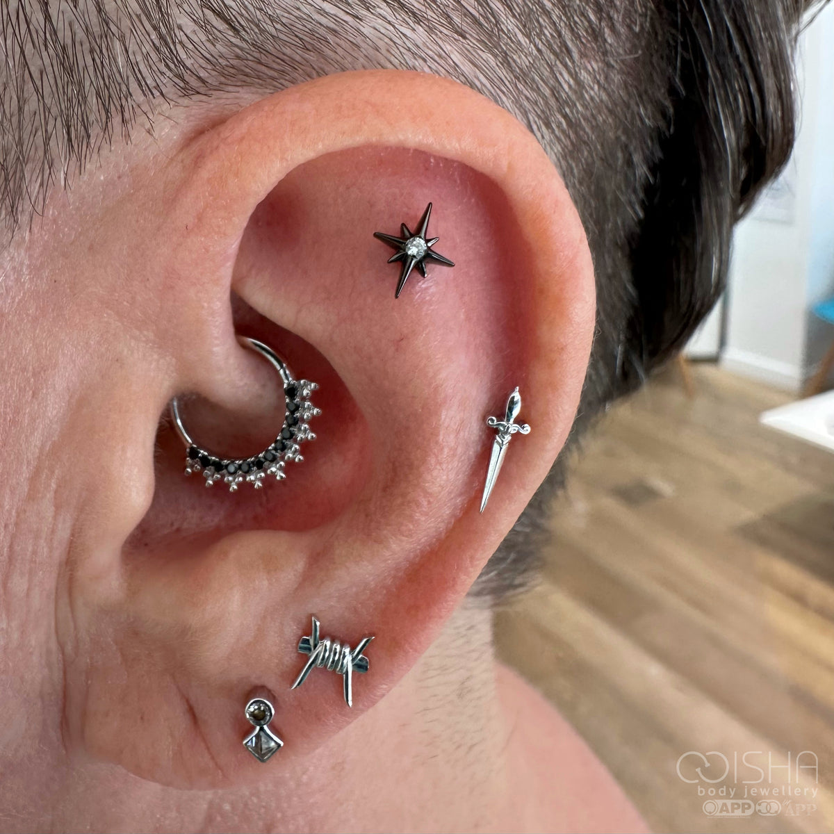 Close-up of an ear with multiple white gold
 earrings