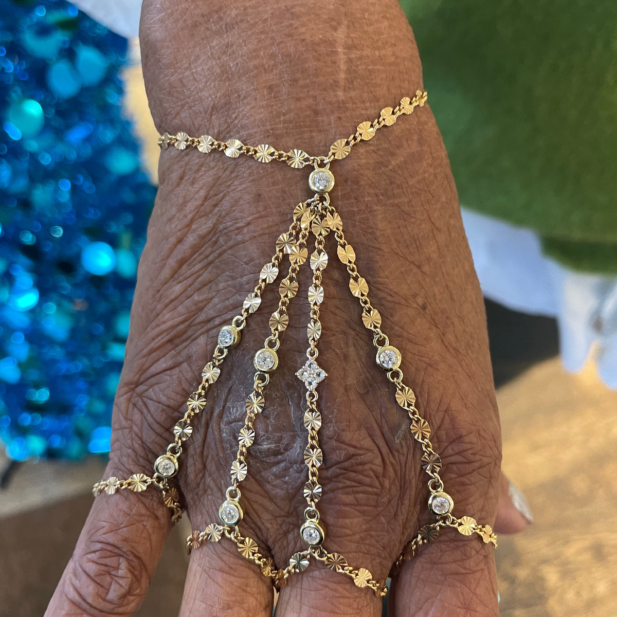 Gold chain bracelet on a wrist with a blurred background